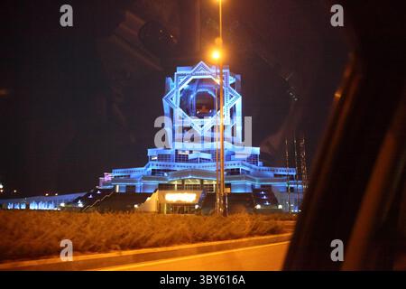 2 settembre 2023. Palazzo dei matrimoni ad Ashgabat illuminato di notte con luci verdi e design futuristico simmetrico. C.. Foto Stock