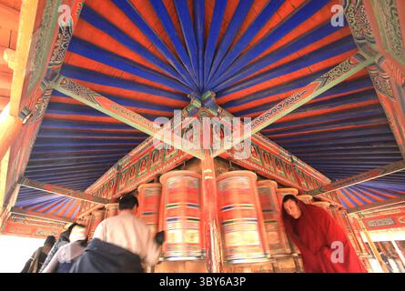 2 febbraio 2012, XIAHE, PROVINCIA DI GANSU, CINA: Nomadi tibetani, pellegrini e monaci girano colorate ruote di preghiera intorno al Monastero di Labrang, il più grande monastero tibetano fuori da Lhasa, prima del Festival tibetano di Monlam a Xiahe, provincia di Gansu sull'altopiano tibetano, 2 febbraio 2012. Decine di migliaia di tibetani celebrano il nuovo anno tibetano giungendo in questa città e nel suo monastero di Labrang, la cui separazione dalla regione autonoma tibetana fornisce una misura di protezione dai tentativi cinesi Han di regolare la loro cultura. (Immagine di credito: © Stephen Shaver/ZUM Foto Stock