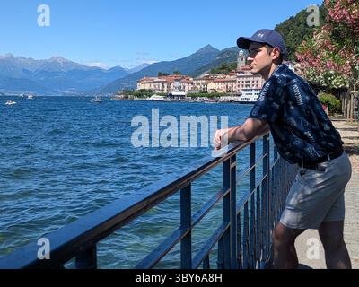 Uomo appoggiato su ringhiera a Bellagio Lago di Como Foto Stock