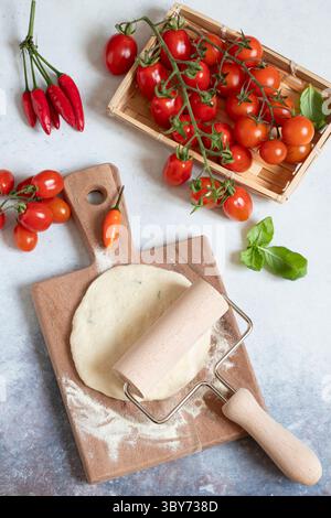 Impasto arrotolato al calzone e pomodori freschi Foto Stock