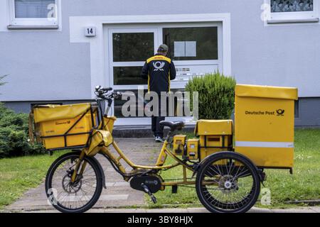 Postman, Deutsche Post, distribuisce la posta in un condominio, triciclo elettrico, Renania settentrionale-Vestfalia, Germania Foto Stock