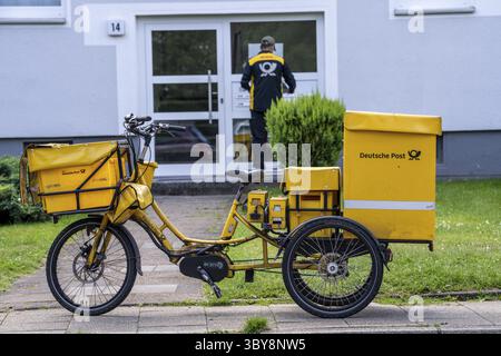 Postman, Deutsche Post, distribuisce la posta in un condominio, triciclo elettrico, Renania settentrionale-Vestfalia, Germania Foto Stock