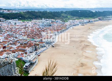 Vista aerea del centro di Nazaré, Portogallo, con le onde dell'oceano che si infrangono sulla vicina costa. Foto Stock