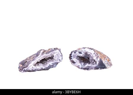 Geode di quarzo e agata isolato su terreno nero bianco. sfondo dettaglio macro. Primo piano di pietre preziose semi-preziose grezze grezze grezze. Foto Stock