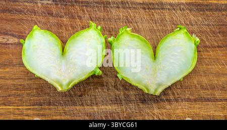 Affascinanti metà di verdure a forma di cuore che mostrano un taglio squisito e unico e una gamma di colori vivaci Foto Stock