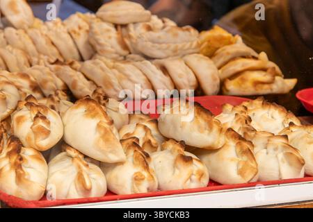 Primo piano di un display con un gran numero di empanadas appena preparate Foto Stock