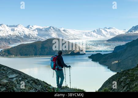 Vista dall'alto dell'uomo che si affaccia sul ghiacciaio Grey e sul Lago Grey, circondato da montagne innevate del massiccio del Paine lungo il percorso escursionistico W-Trek in a. Foto Stock