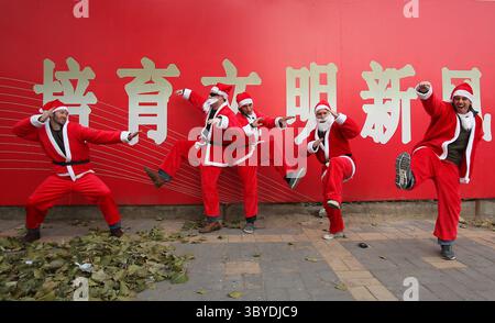 11 dicembre 2010, PECHINO, CINA: Gli stranieri vestiti con i costumi di Babbo Natale colpiscono kong fu posa su un marciapiede mentre si dirigono verso Piazza Tienanmen per SantaCon, una convention annuale di Babbo Natale che celebra il saluto, la buona volontà e il divertimento, a Pechino December111, 2010. La polizia di Piazza Tienanmen, sorpreso dal grande raduno di persone che indossano il rosso, ordinò al gruppo di disperdersi e lasciare la piazza, molestando anche giornalisti stranieri, arrestandone uno. Piazza Tiananmen era sotto stretta sicurezza in quanto la cerimonia del Premio Nobel per la pace si tenne in Norvegia. (Immagine di credito: © Stephen Shaver/ZUMA Foto Stock