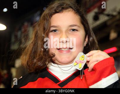 11 novembre 2011 - Detroit, Michigan, USA - Meghan McDonald di dieci anni di Sarnia, Michigan, regge una delle piastrine consegnate ai fan mentre entravano nella Joe Louis Arena per la partita dei Detroit Red Wings contro gli Edmonton Oilers a Detroit, Michigan, venerdì 11 novembre 2011. Le targhette erano in onore del Veterans Day. (Immagine di credito: © Julian H. Gonzalez/Detroit Free Press via ZUMA Press Wire) Foto Stock