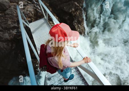 Escursionista donna in piedi sul ponte godendo delle vacanze attive sul fiume in Norvegia, escursionismo turistico femminile esplorazione in solitaria di sentieri naturali in SCA Foto Stock
