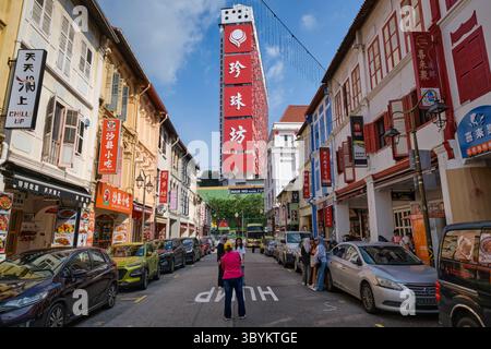 Vista lungo Temple Street, Chinatown, Singapore, con numerosi edifici storici colorati e nella torre simbolo del People's Park Complex Foto Stock