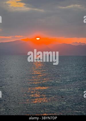 Tramonto sul Lago di Garda da Cisano vicino a Botdolino. Fai un tuffo nei riflessi del tramonto Foto Stock