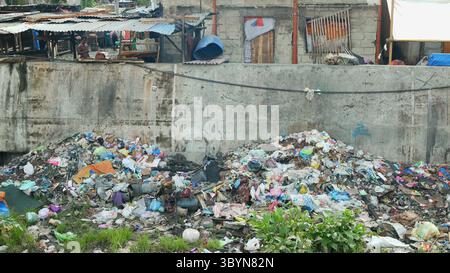 MANDAUE CITY, FILIPPINE, 15 GIUGNO 2025: Plastica immondizia baraccopoli filippina poveri rifiuti fluviali baraccopoli rifiuti discarica inquinamento fecale di Tipolo Creek Foto Stock