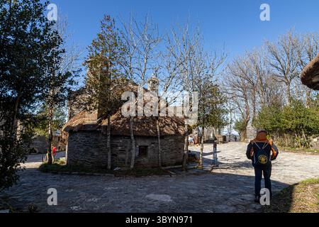 O Cebreiro, Spagna. Pallozas tradizionali in paglia nel villaggio di montagna di o Cebreiro circondato dal paesaggio della Galizia e dalle colline della Cam Foto Stock