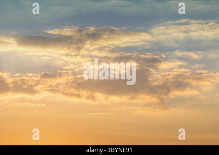 Tramonto cielo nuvole in serata con luce arancione, gialla e blu all'ora d'oro dopo il tramonto. Cielo romantico in estate Foto Stock