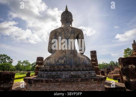 Statua di Buddha retroilluminata presso le rovine del tempio Wat Mahathat nel Parco storico di Sukhothai, Thailandia. Foto Stock