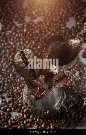 Concetto Falling Coffee Beans, primo piano di chicchi di caffè appena tostati che volano su sfondo scuro Foto Stock