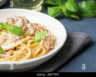 Pasta alla carbonara, spaghetti con pancetta, uova, parmigiano e salsa alla panna. Cucina tradizionale italiana. Vista laterale, primo piano Foto Stock