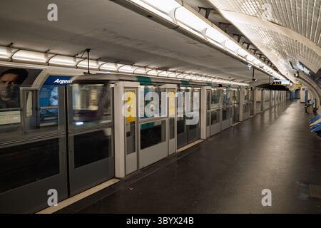 Un po' di movimento mentre un moderno treno della metropolitana di Parigi arriva alla stazione di Argentin, catturato dalla piattaforma in Francia. Foto Stock