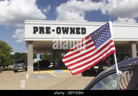 Concessionario di automobili usato con American Flag Shallow DOF, Focus su flagpole Foto Stock