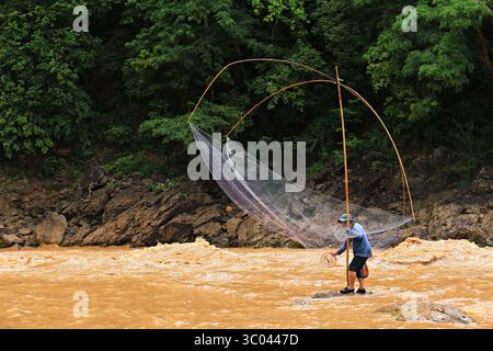 Pescatori che utilizzano attrezzature per la pesca a rete (rete quadrata) per la cattura di pesci a Kaeng Luang, provincia di Nan, Thailandia Foto Stock