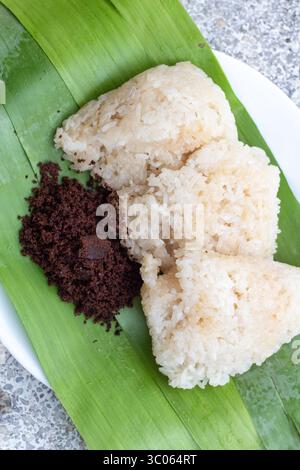Il puto maya o riso appiccicoso ricoperto di zucchero muscovado su foglia di banana è una colazione popolare a Cebu, nelle Filippine Foto Stock