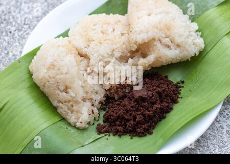 Il puto maya o riso appiccicoso ricoperto di zucchero muscovado su foglia di banana è una colazione popolare a Cebu, nelle Filippine Foto Stock