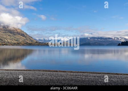 Wanaka, Otago, nuova Zelanda, paesaggio del lago Wanaka dalla spiaggia di Wanaka in una giornata di sole autunno con vista sulla Roys Bay fino alla catena montuosa del Monte alta Foto Stock