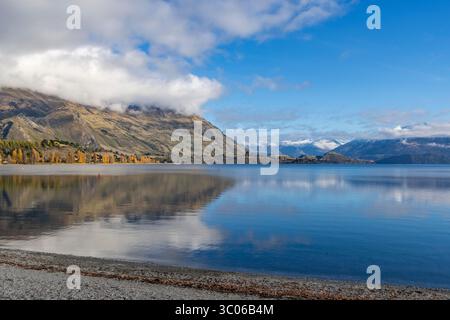 Wanaka, Otago, nuova Zelanda, paesaggio del lago Wanaka dalla spiaggia di Wanaka in una giornata di sole autunno con vista sulla Roys Bay fino alla catena montuosa del Monte alta Foto Stock