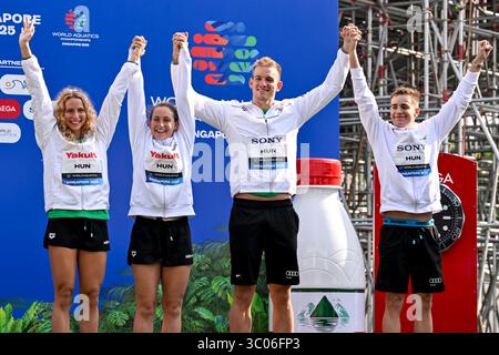 Bettina Fabian, Viktoria Mihalyvari-Farkas, David Betlehem, Kristof Rasovszky dell'Ungheria festeggiano dopo aver vinto la medaglia di bronzo nella finale mista di nuoto in acqua aperta 4x1500m durante il 22° Campionato Mondiale di Aquatica a Sentosa a Singapore (Singapore), 20 luglio 2025. Foto Stock