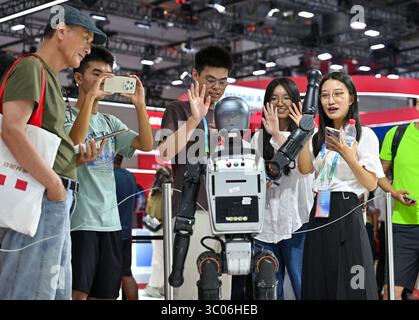 I visitatori interagiscono con un robot umanoide. Pechino, Cina. 19 luglio 2025. La terza China International Supply Chain Expo apre al pubblico a Pechino, 19 luglio 2025. Crediti: Zhao Wenyu/China News Service/Alamy Live News Foto Stock