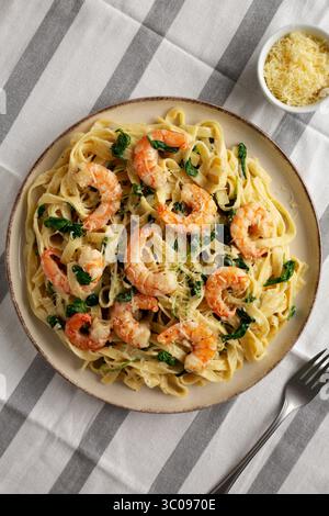 Pasta cremosa di gamberi di spinaci fatta in casa su un piatto, vista dall'alto. Foto Stock