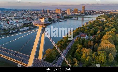 Vista aerea dell'iconico ristorante UFO in cima al ponte SNP che riflette la luce dorata del crepuscolo sul Danubio, Bratislava, regione di Bratislava, Slovacchia. Foto Stock
