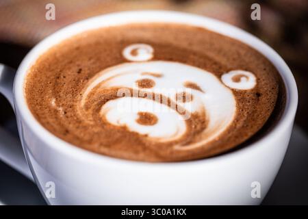 Primo piano del latte schiumoso con schiuma Art nella luce del mattino Foto Stock