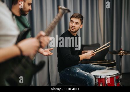 Membri della band che praticano musica insieme in una sala prove professionale Foto Stock
