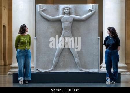 Londra, Regno Unito. 21 luglio 2025. Membri dello staff con «Primeval Gods» 1910, 1931-3, di Jacob Epstein in una nuova esposizione di opere dell'influente scultore britannico del XX secolo Jacob Epstein alla Tate Britain. Sculture monumentali in pietra e busti ritratti in bronzo sono in mostra nelle gallerie Duveen. Crediti: Stephen Chung / Alamy Live News Foto Stock