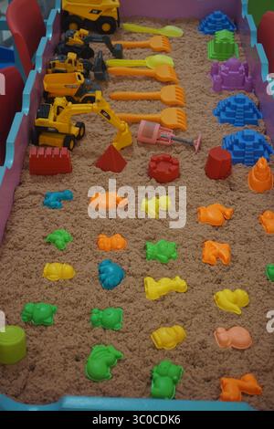Scatola di sabbia ordinata piena di un assortimento di giocattoli di plastica lucida in un centro commerciale di Depok Indonesia il 18 luglio 2025. Foto Stock