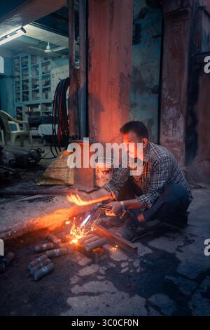 Rajasthan, Jaipur, India - Sparks volano mentre un saldatore forma metallo e fuoco, un momento grezzo di forza, abilità e precisione per le strade Foto Stock