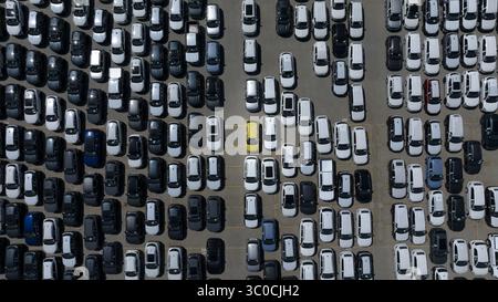 Vista aerea di file ordinate di auto parcheggiate, un mare di veicoli monocromatici punteggiati da una singola auto gialla vibrante, Fremantle, Australia Occidentale, Aust Foto Stock