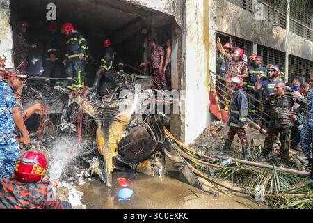 Dacca. 21 luglio 2025. I vigili del fuoco lavorano nel sito dell'incidente a Dacca, Bangladesh, il 21 luglio 2025. Almeno 19 persone, per lo più studenti, sono state uccise mentre un aereo da addestramento della Bangladesh Air Force si è schiantato nel campus di un college qui lunedì. Una dichiarazione del governo ha affermato che oltre 100 persone sono rimaste ferite nell'incidente. Molti dei feriti sono in condizioni critiche. L'Inter Service Public Relations (ISPR) dell'esercito del Bangladesh ha detto che l'aereo da addestramento si è schiantato intorno alle 13:30 ora locale. Crediti: Xinhua/Alamy Live News Foto Stock