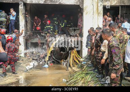 Dacca. 21 luglio 2025. I vigili del fuoco lavorano nel sito dell'incidente a Dacca, Bangladesh, il 21 luglio 2025. Almeno 19 persone, per lo più studenti, sono state uccise mentre un aereo da addestramento della Bangladesh Air Force si è schiantato nel campus di un college qui lunedì. Una dichiarazione del governo ha affermato che oltre 100 persone sono rimaste ferite nell'incidente. Molti dei feriti sono in condizioni critiche. L'Inter Service Public Relations (ISPR) dell'esercito del Bangladesh ha detto che l'aereo da addestramento si è schiantato intorno alle 13:30 ora locale. Crediti: Xinhua/Alamy Live News Foto Stock