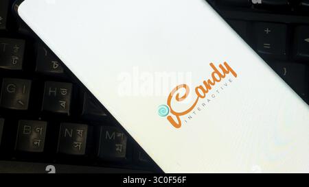 Smartphone con logo iCandy posizionato su una tastiera nera con caratteri stranieri Foto Stock