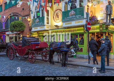 Cavalli e carrozze fuori dal Oliver St. John Gogarty Bar in Fleet Street nel quartiere di Temple Bar, nel centro di Dublino. Foto Stock