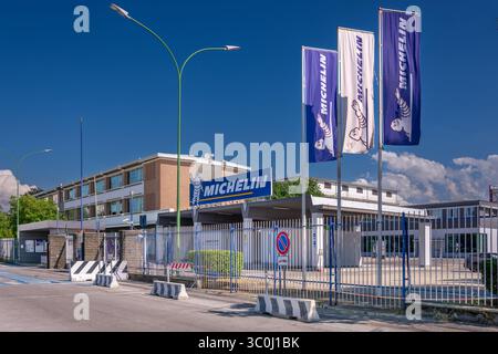 Cuneo, Italia - 21 luglio 2025: Veduta dell'ingresso dello stabilimento di produzione italiana di pneumatici dell'azienda Michelin con il logo Michelin e le bandiere Foto Stock