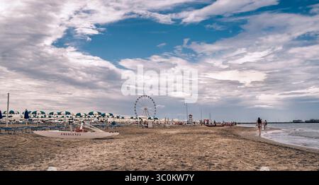 Un pomeriggio estivo piovoso sulla spiaggia di Rimini. in primo piano una barca a remi catamarana per il salvataggio. Riviera Adriatica, Emilia-Romagna, Italia. Foto Stock