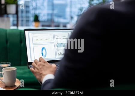 Un leader aziendale sicuro esamina le tendenze di vendita e i rapporti sul budget nel suo ufficio intelligente, garantendo redditività e successo aziendale attraverso processi decisionali e una pianificazione strategica efficaci. Foto Stock