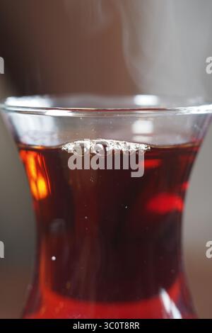 Tazza di tè al vapore con bollicine e colore intenso Foto Stock