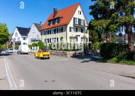 LINDAU, GERMANIA - 31 MAGGIO 2025: Lungo il marciapiede è parcheggiata una caratteristica Citroën 2CV d'epoca gialla, aggiungendo un tocco di classico fascino europeo Foto Stock