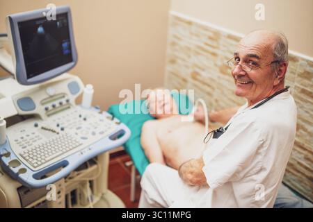 Il paziente anziano sta effettuando un esame ecografico del suo cuore da parte di un medico esperto. Foto Stock
