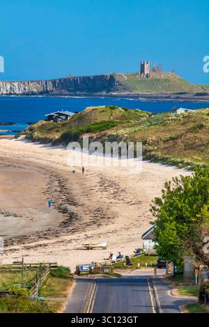 Una vista in estate in una giornata di sole guardando lungo la spiaggia verso il castello di Dunstanburgh da Low Newton Foto Stock